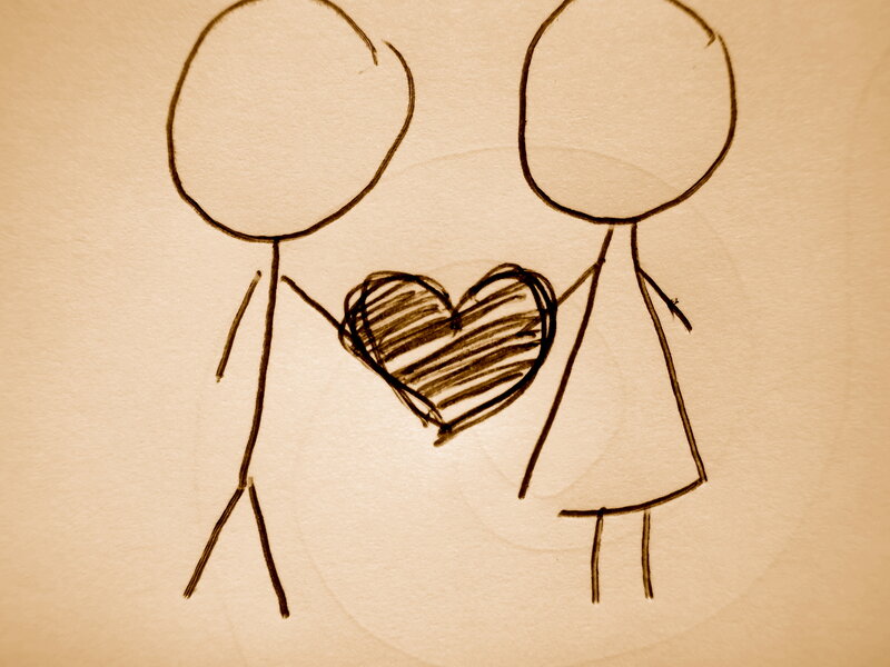two stick figures holding a heart