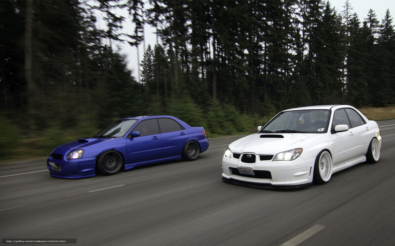Two Subaru cars on a road