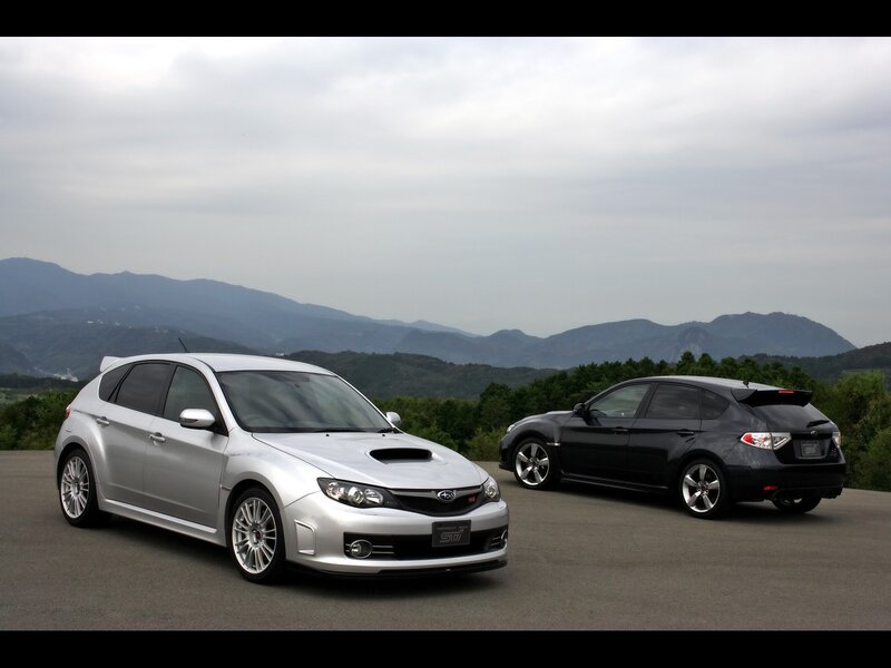 Two Subaru WRX STI cars on a mountain road