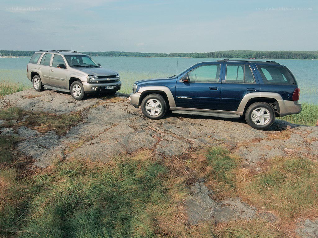 Two SUVs on a rocky shore
