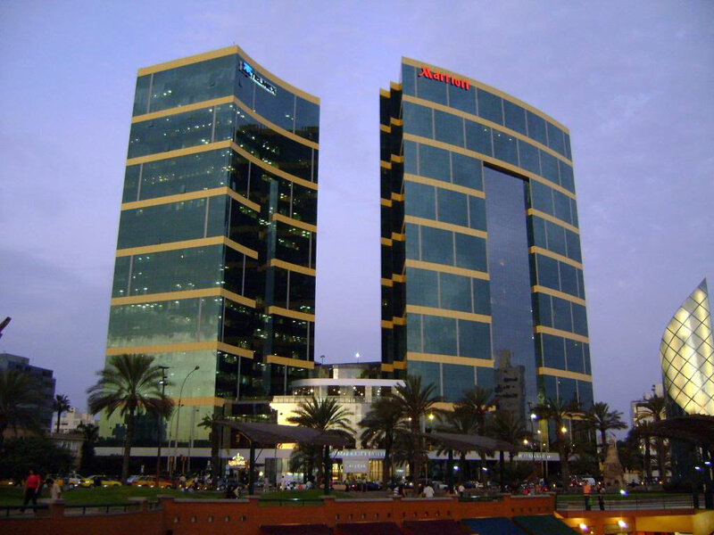Two tall glass buildings at dusk
