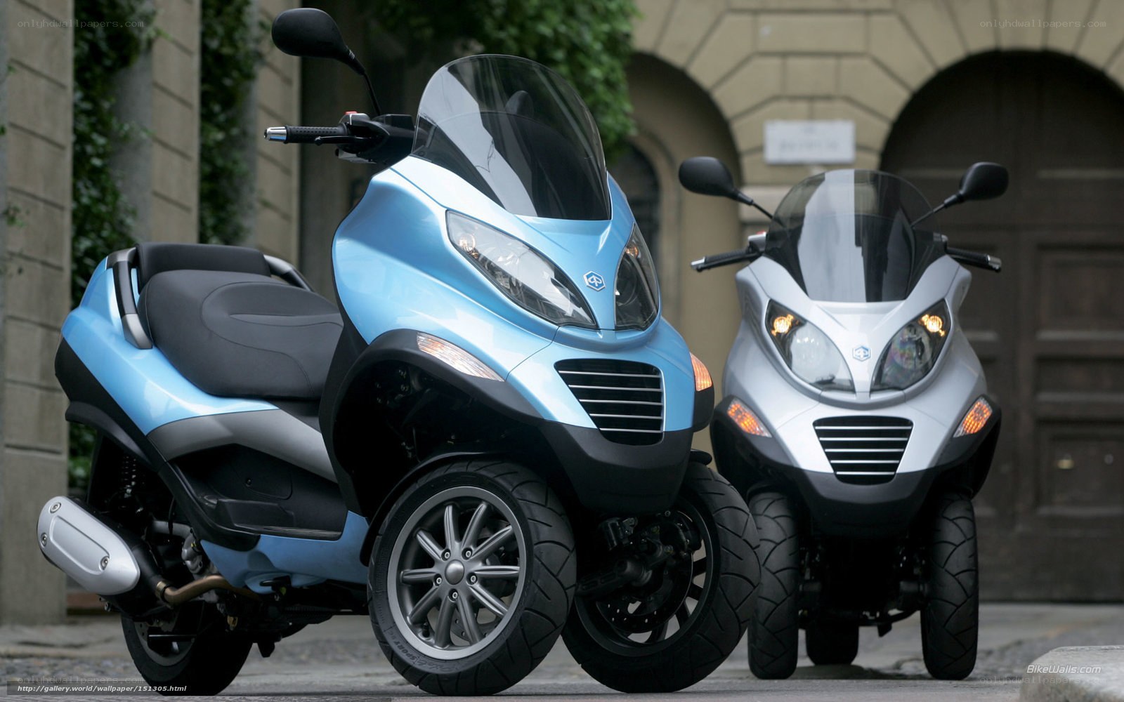 Two three-wheeled scooters parked
