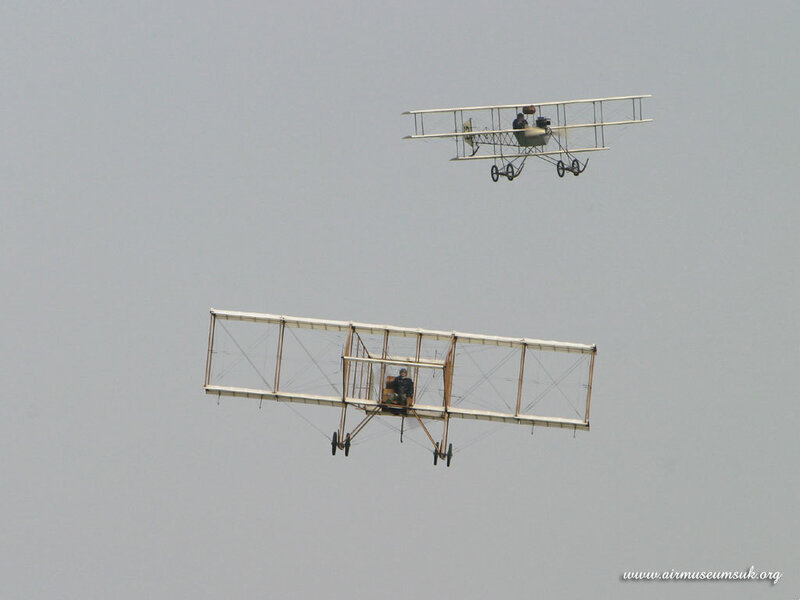Two vintage biplanes in flight