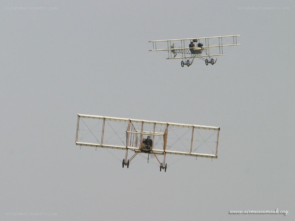 Two vintage biplanes in flight