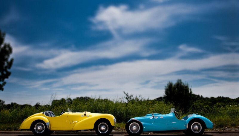 Two vintage cars on a road