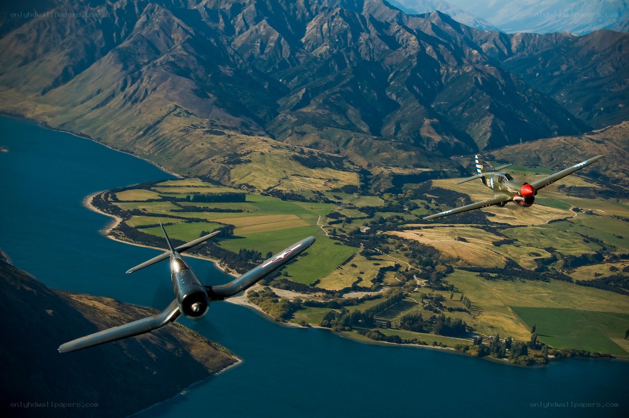 Two vintage planes over a lake
