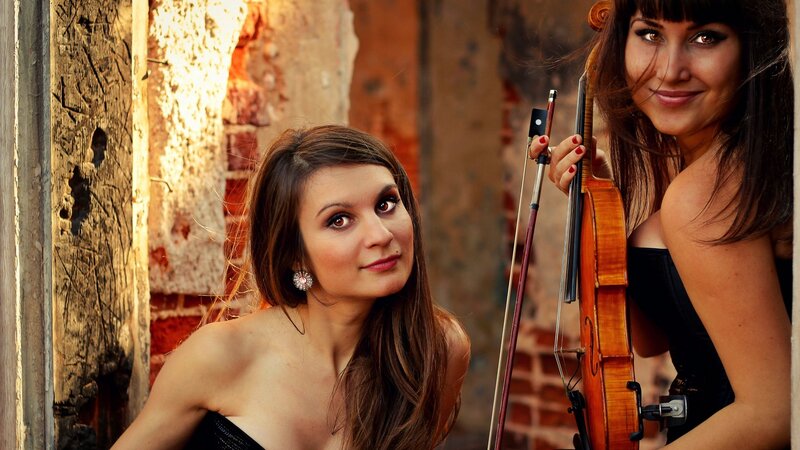 Two violinists in a rustic setting