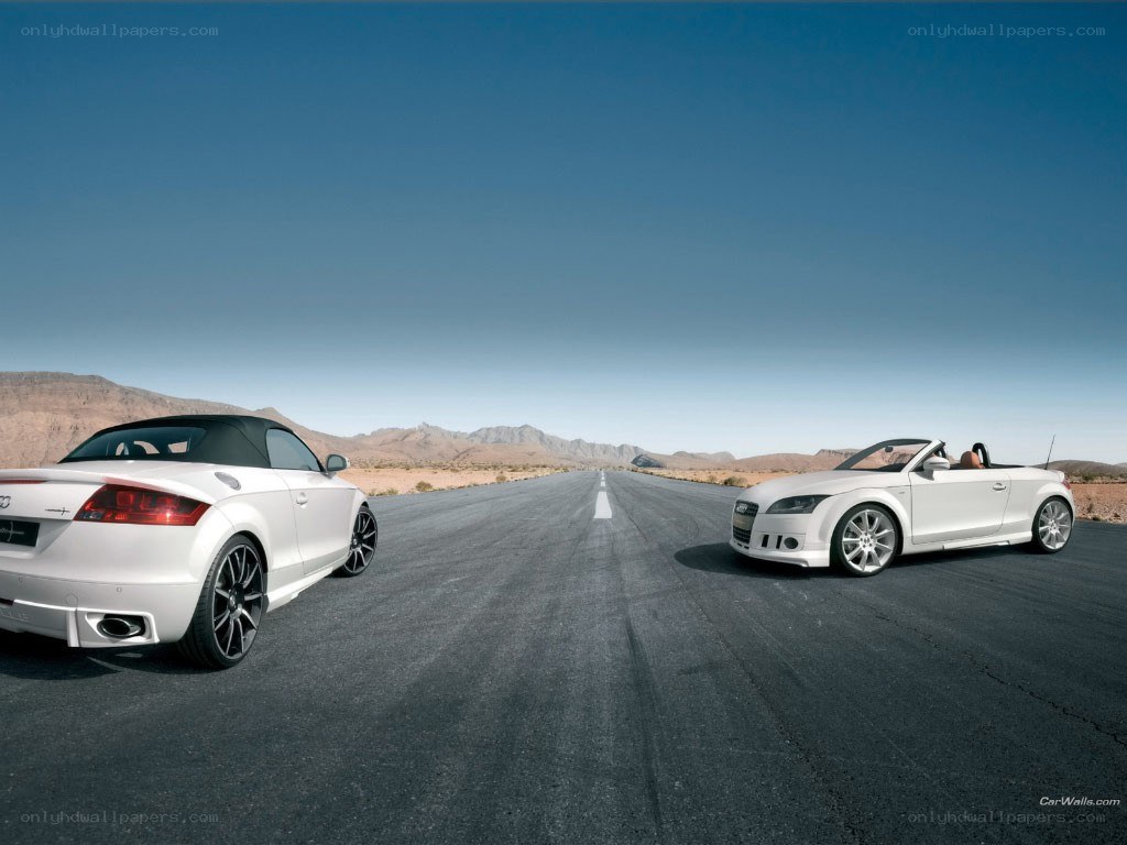 Two white convertibles on a desert road