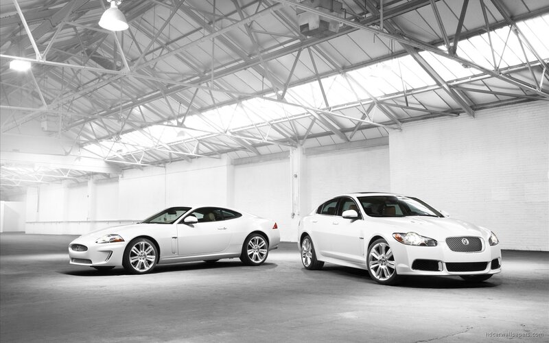 Two white Jaguar cars in a warehouse