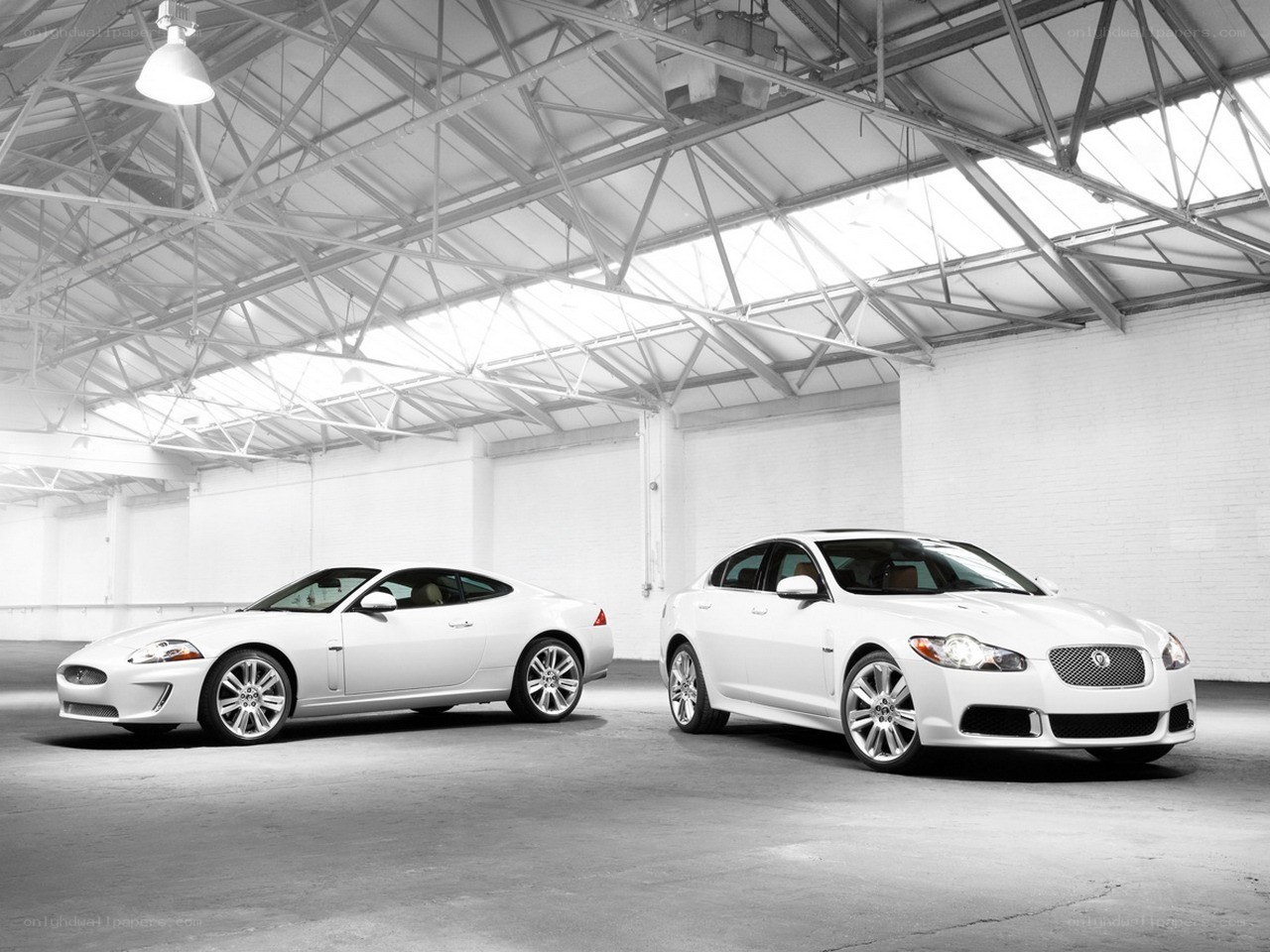 Two white Jaguars in a warehouse