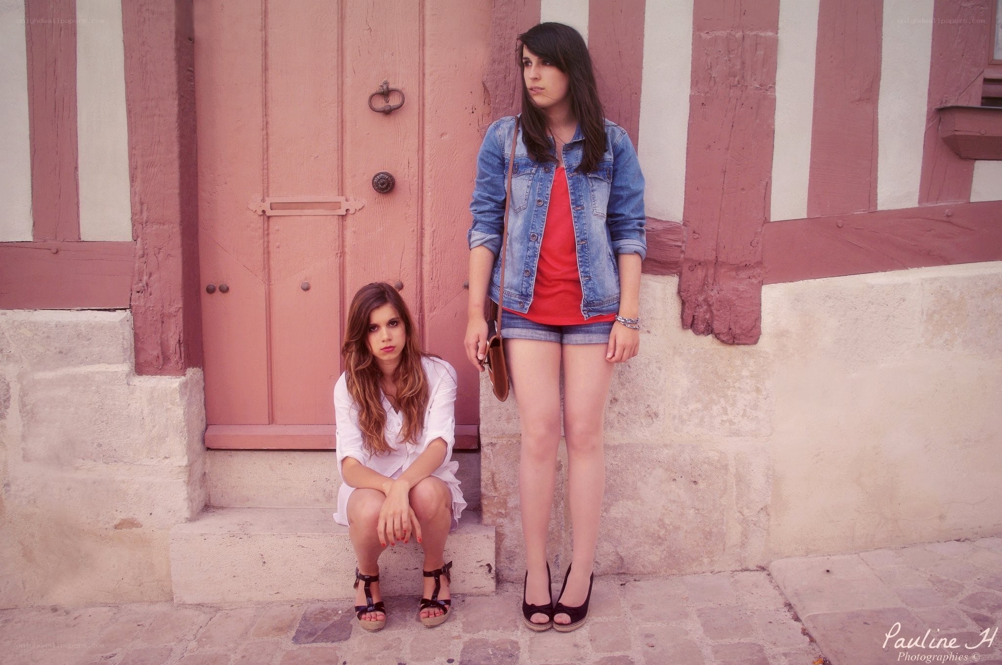 Two women by a pink door