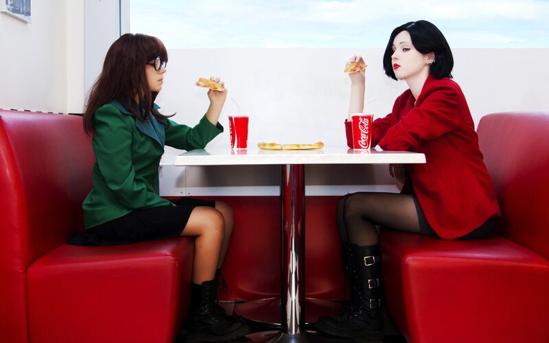 Two women eating pizza in a diner