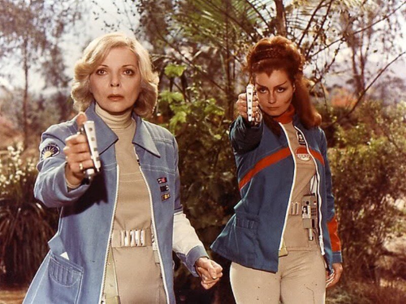 Two Women Holding Guns — Blue