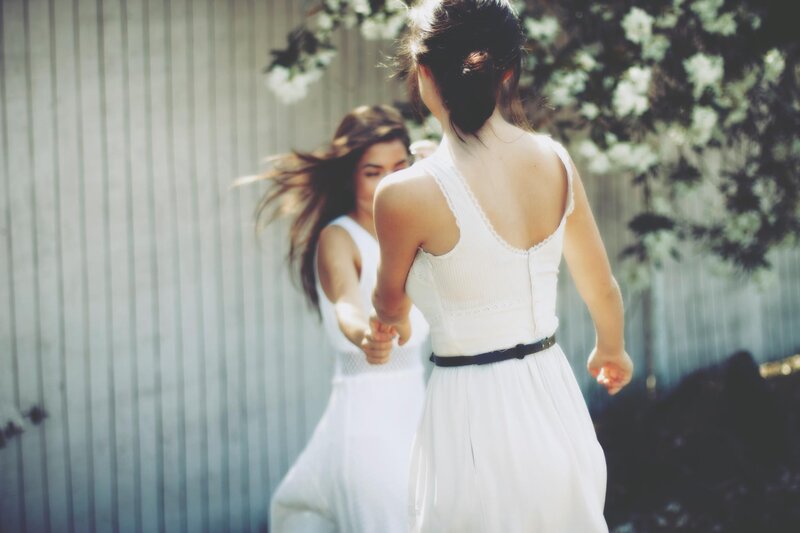 Two women holding hands outdoors