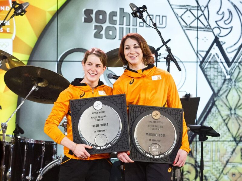 Two Women Holding Medals