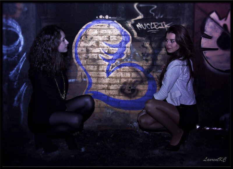 Two women in a graffiti alley