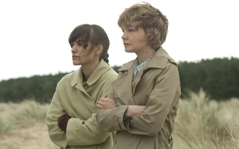 two women in coats on a beach