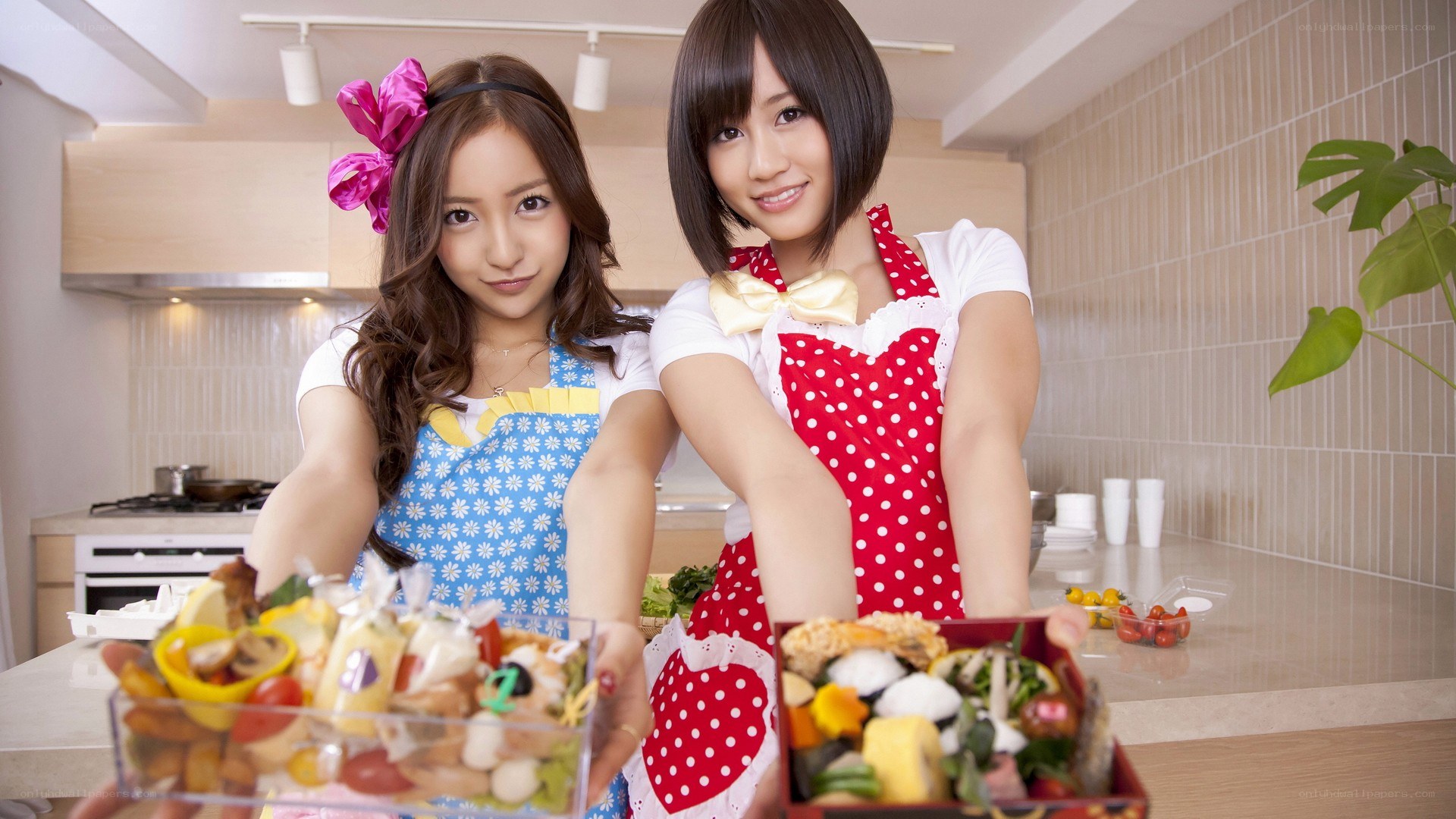 Two women in kitchen with bento boxes