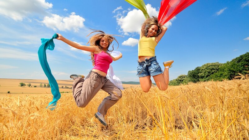 Two Women Jumping in Field