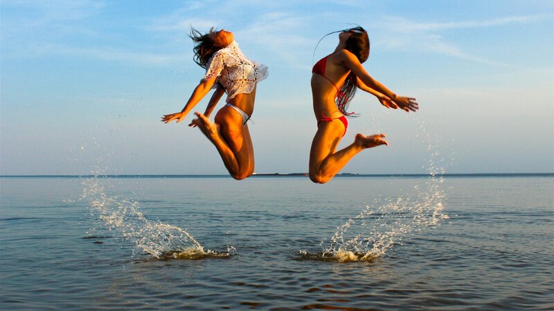 Two women jumping in the water