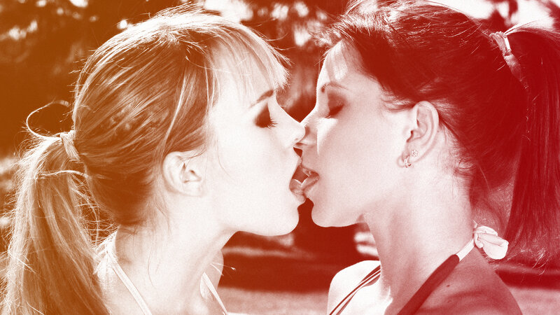 two women kissing outdoors