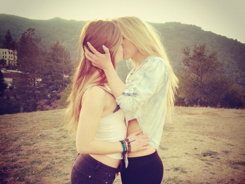 two women kissing outdoors