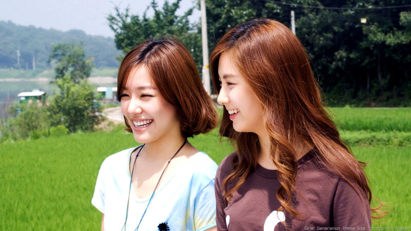 two women laughing in a field