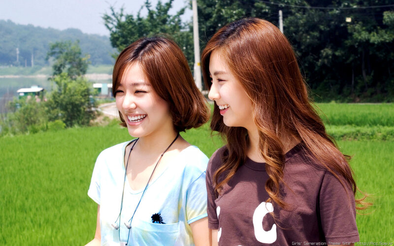 two women laughing in a field