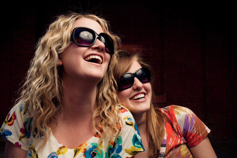 two women laughing in sunglasses
