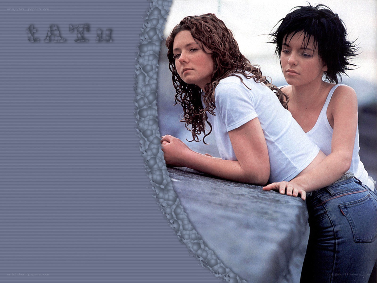 two women leaning on a wall