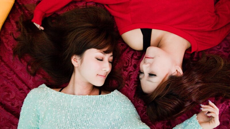Two women lying on a bed