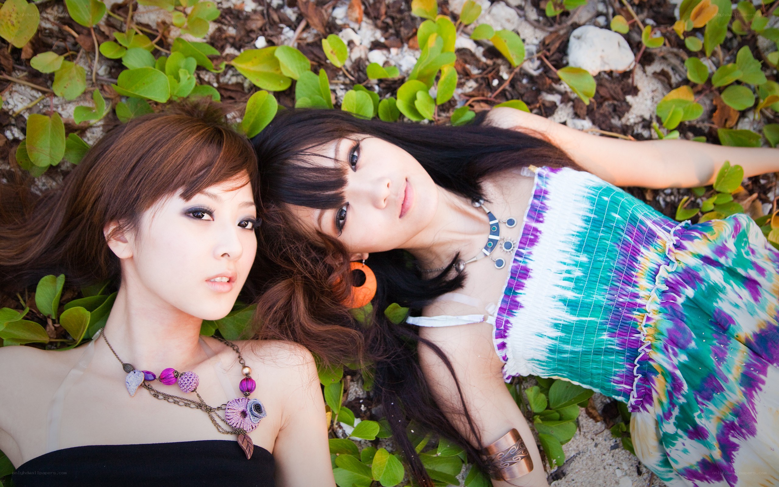 Two women lying on foliage