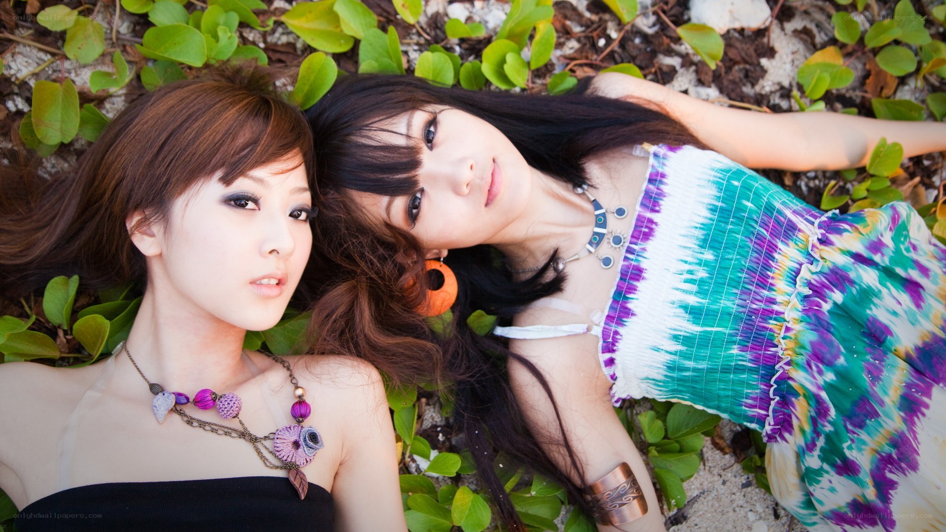 two women lying on foliage