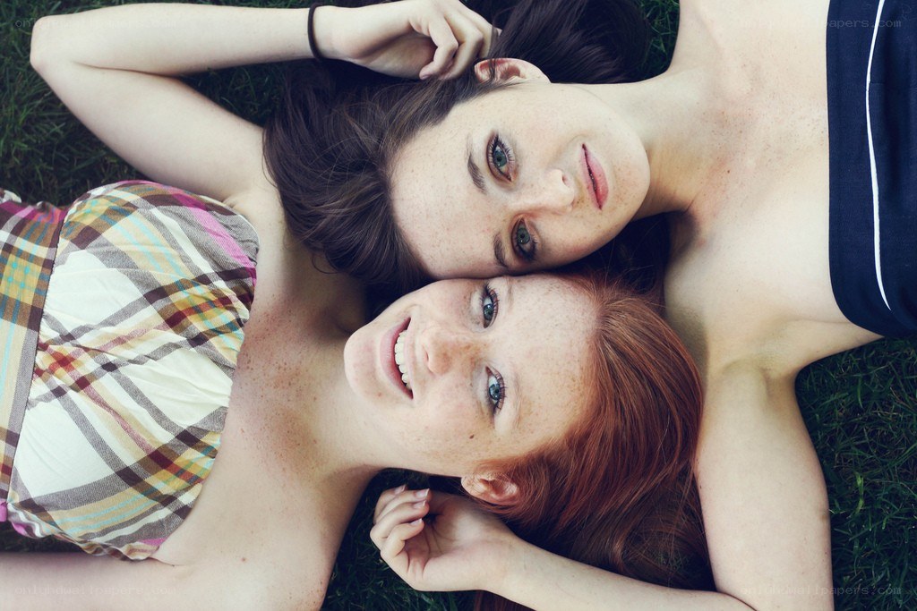 Two women lying on grass