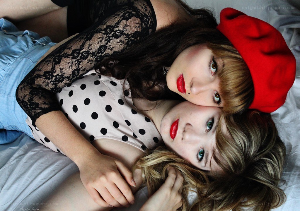 Two women lying together on a bed