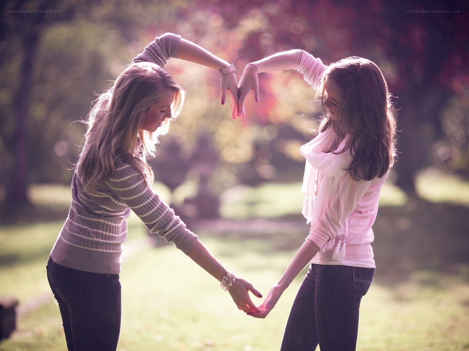Two women making a heart shape