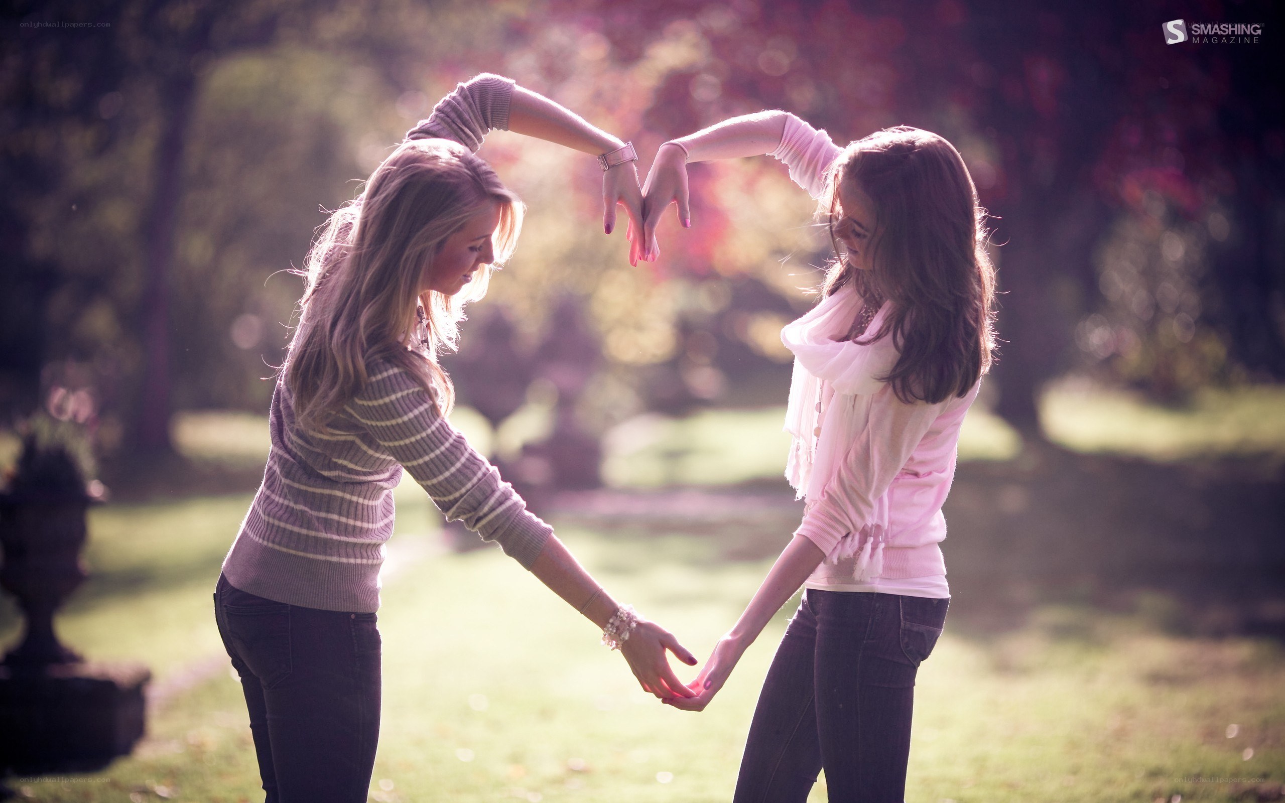Two women making a heart shape