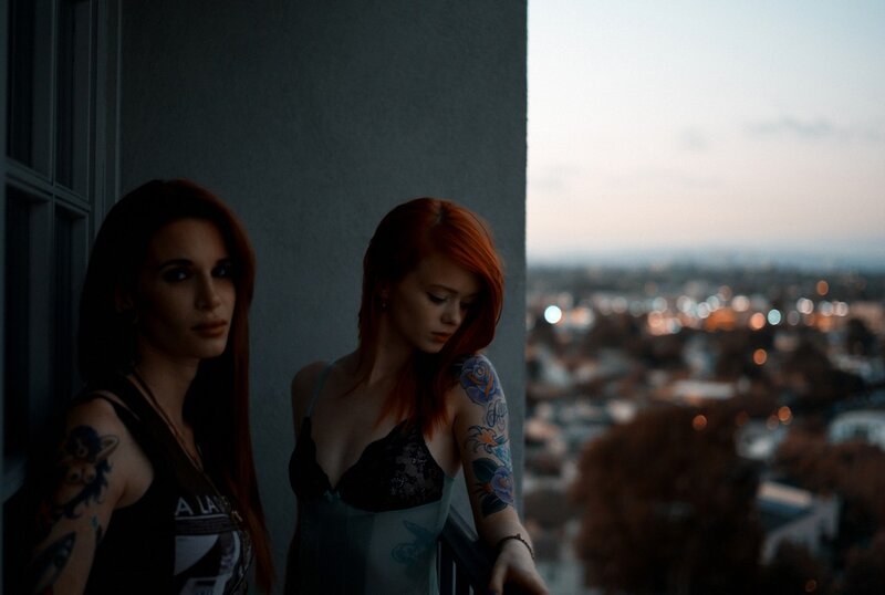 Two women on a balcony at dusk