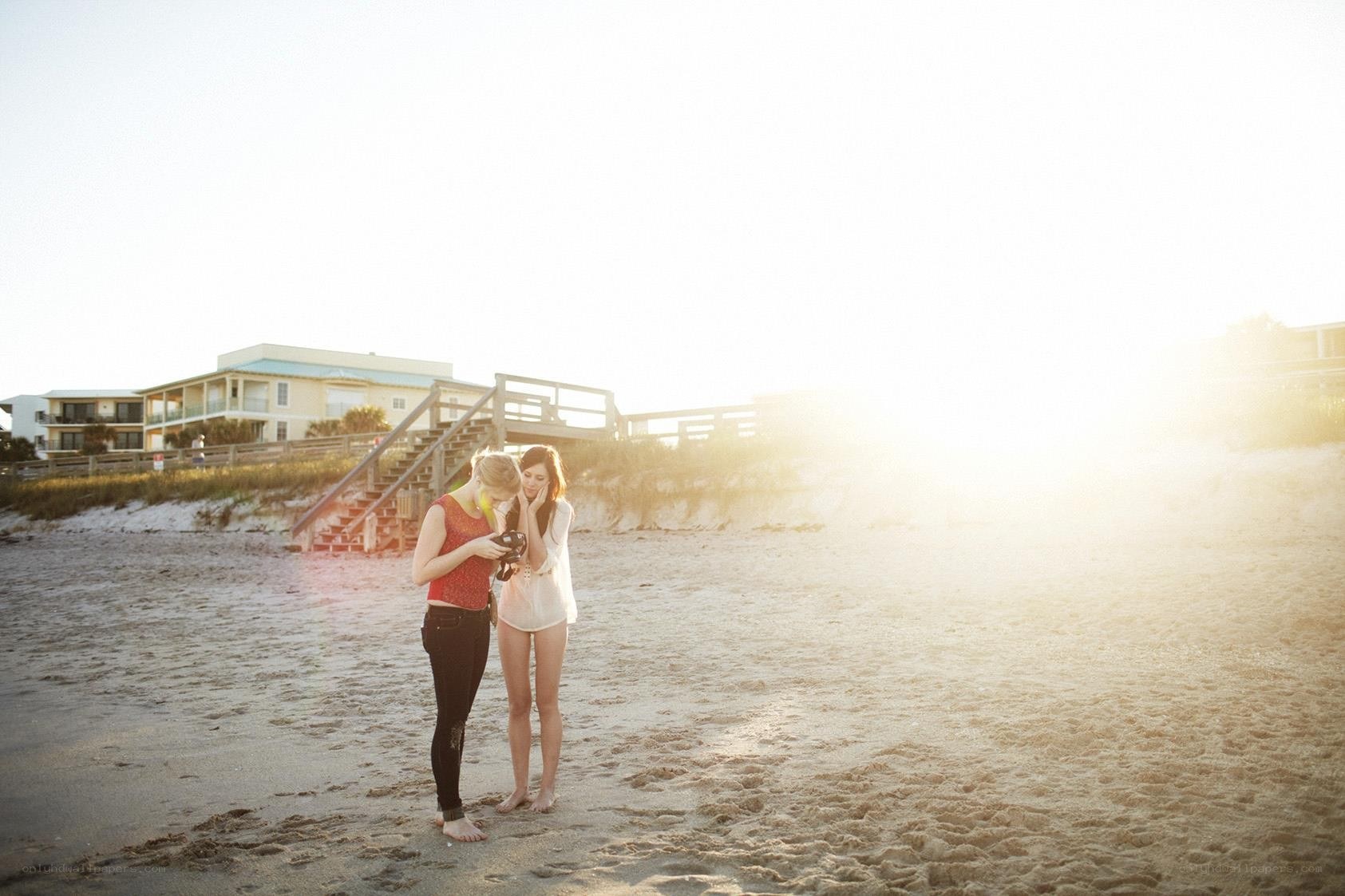Two women on a beach at sunset