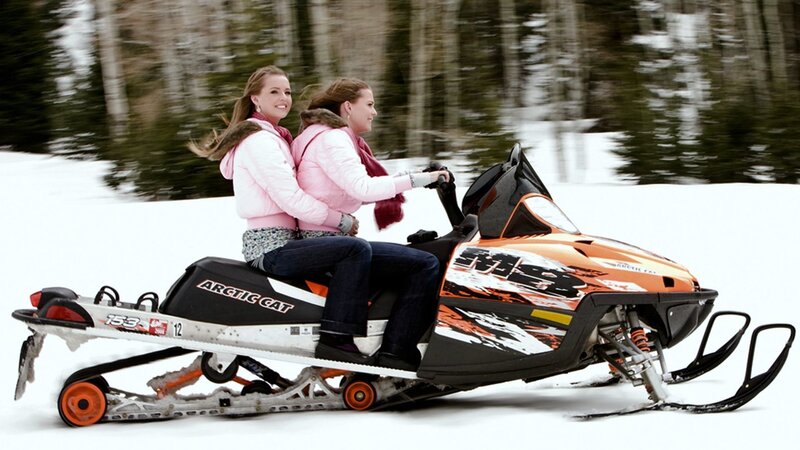 Two Women on Snowmobile — Orange