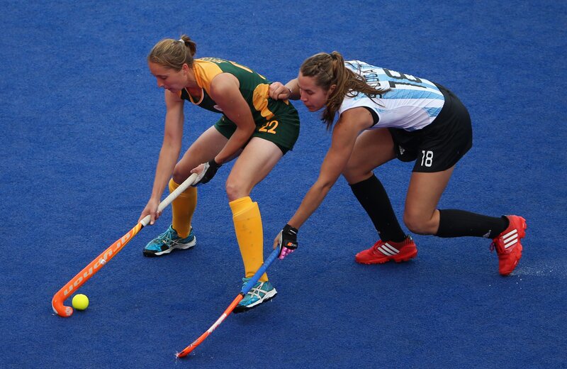 Two Women Playing Field Hockey — Blue