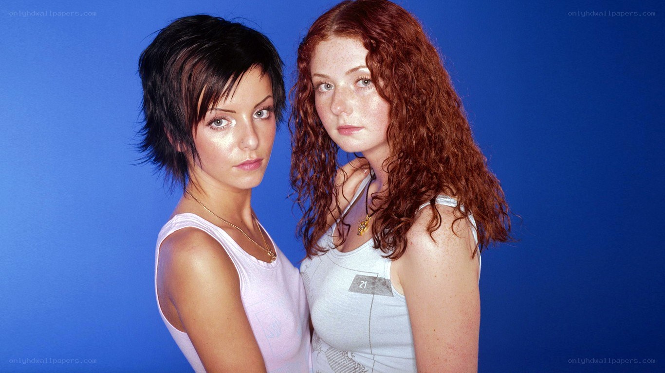 two women posing against blue background