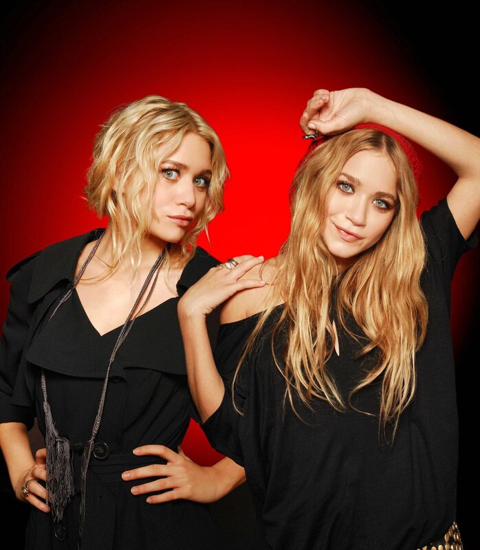 Two women posing against red background