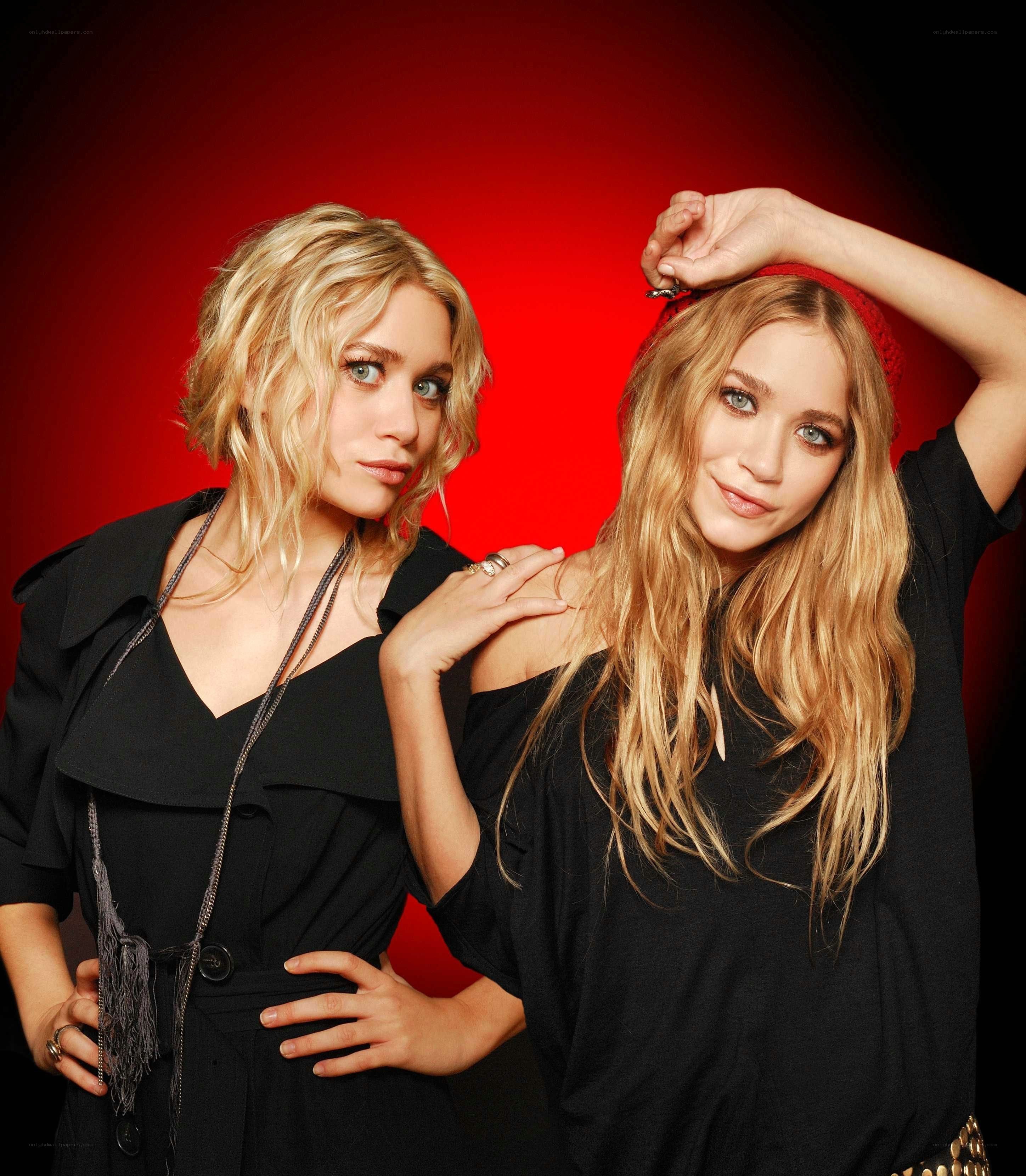 Two women posing against red background