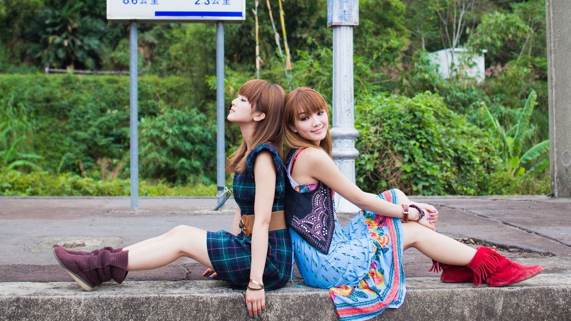 Two women sitting back-to-back
