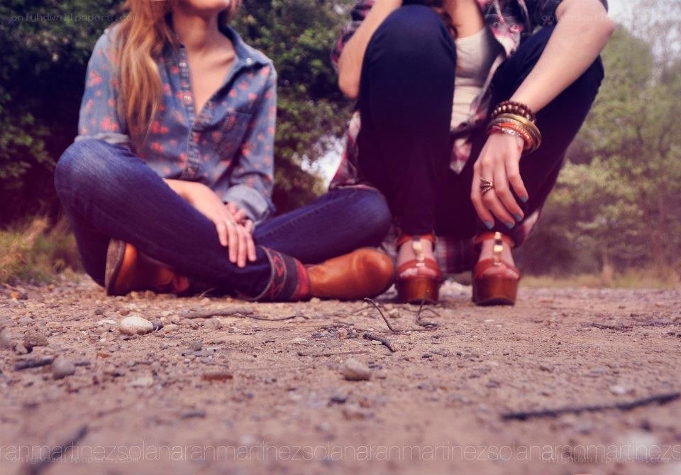 two women sitting on a path