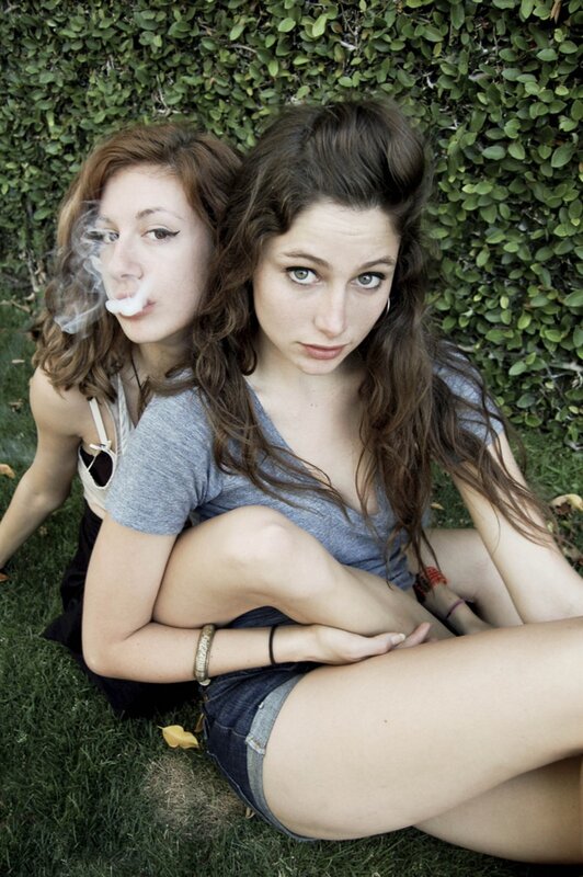 two women sitting on grass