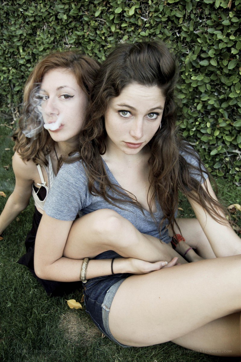two women sitting on grass