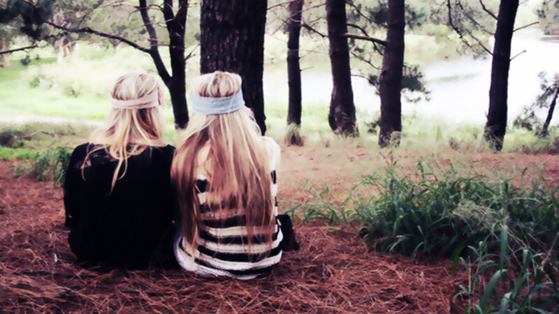 Two Women Sitting on Ground