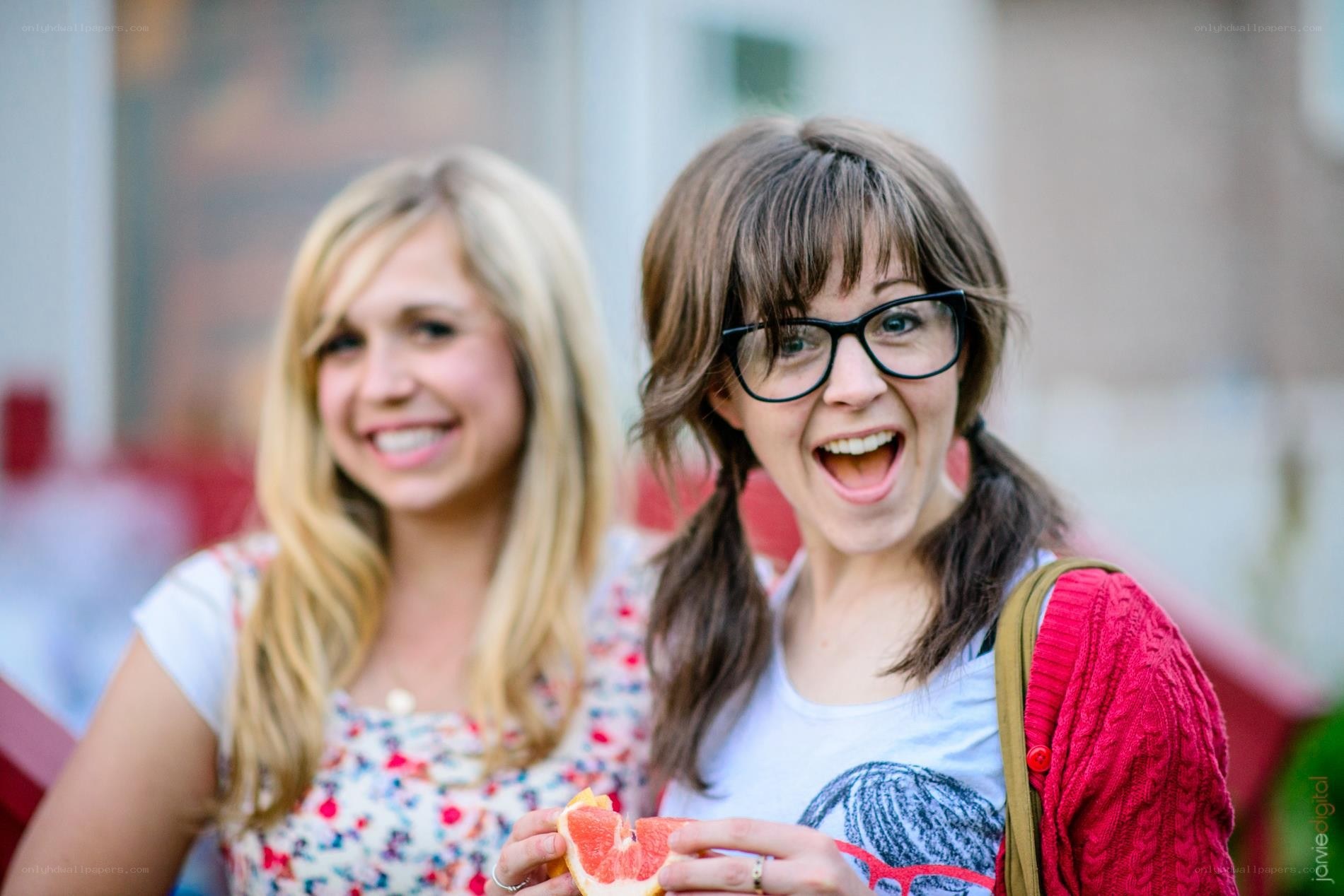 Two women smiling with grapefruit